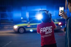 Filming on location at night in a Fapic Group shirt